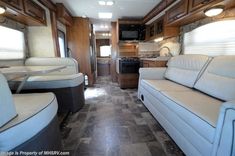 the interior of an rv with couches and kitchen