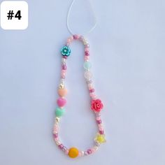 a necklace made with beads and flowers on a white background, the number four is 4