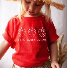 Your toddler will look adorable in this cute tshirt that features strawberries and the words Be a Sweet Human. This super soft tee is perfect for infants and toddlers sensitive skin. Make a great gift for a strawberry lover. * Q U I C K * F A C T S * ♥ 100% cotton ♥ Design is high quality digital print ♥ Wash and dry normally (on cool for best results) * S I Z I N G * ♥ 2T: 30-33 lb / 32-35'' ♥ 3T: 33-36 lb / 35-38'' ♥ 4T: 36-40 lb / 38-40'' ♥ 5T: 40-45 lb / 40-43'' ♥ Please see size guide in li Sweet Red Summer Tops, Fun Strawberry Print Crew Neck T-shirt, Sweet Strawberry Print Crew Neck Top, Sweet Red Crew Neck Top, Red Crew Neck T-shirt, Cute Strawberry Print Crew Neck T-shirt, Cute Crew Neck T-shirt With Strawberry Print, Sweet Short Sleeve Tops With Fruit Print, Cute Funny Print T-shirt