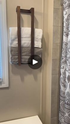 a white toilet sitting next to a bathroom sink under a mirror and towel rack on the wall