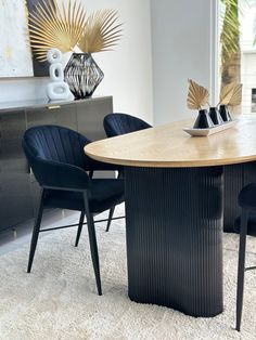 a dining room table with black chairs around it