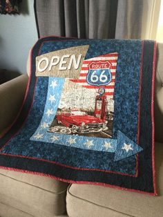 a couch with a quilt on it that says open route 66 and an american flag