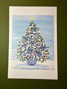 a painting of a christmas tree in a blue and white vase on a green surface