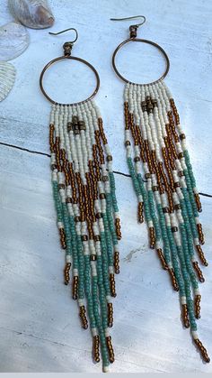 S o o r a j   earrings were handcrafted using colors matte cream, gold luster, Picasso turquoise and bronze with high quality Japanese seed beads. Suspended from hand crafted  antique brass hoops using quality Japanese nylon thread for durability. These come with silicone encapsulated antique brass backs to secure your earrings. Nickel and lead free. *LAST PICTURE IS FOR SIZE REFERENCE ONLY * Fringes swing beautifully and are light weight.  **Please care for your jewelry as you would with any va Beige Bohemian Fringe Earrings, Handmade White Bohemian Tassel Earrings, White Bohemian Fringe Earrings, Bohemian Dangle Fringe Hoop Earrings, Bohemian Fringe Dangle Hoop Earrings, Bohemian Beige Dangle Jewelry, Handmade Beige Dangle Jewelry, Beige Handmade Dangle Jewelry, Bohemian Beige Beaded Earrings For Gifts