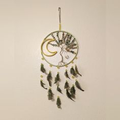 a dream catcher with feathers hanging from it's side and a crescent in the middle