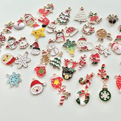 many different types of christmas ornaments on a white surface with snowflakes and santa's hats