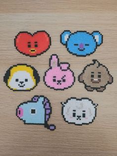 six pixelated animal stickers on a wooden surface, each with different colors and shapes