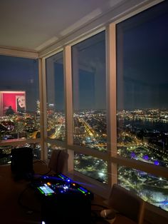 a room with large windows overlooking the city at night