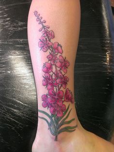 a woman's foot with a flower tattoo on the left side of her leg