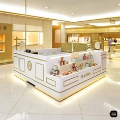 the interior of a jewelry store with white counter tops and gold trimmings on the walls