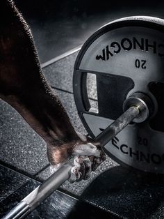 a person is lifting a barbell in the gym