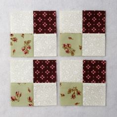 four patchwork squares with red and white flowers on them are arranged in the same pattern