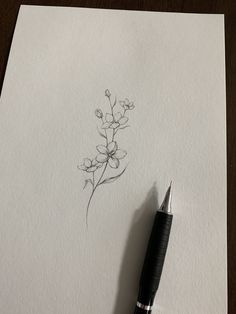 a pen is sitting on top of a piece of paper with a flower drawn on it