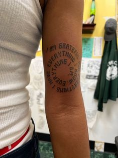 a woman with a tattoo on her arm that says i am grateful everything is wrong