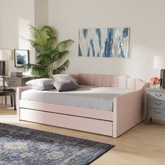 a bedroom with a pink bed and blue rug