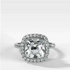 an engagement ring with a cushion cut diamond surrounded by halos and pave diamonds