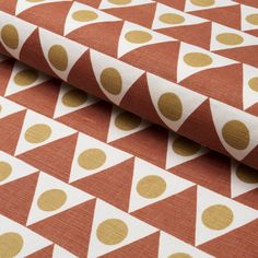 an orange and white wallpaper with gold polka dot design on it's fabric