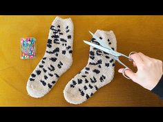 someone using scissors to cut up socks on a table with other items around the room