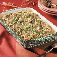 a casserole dish filled with stuffing on top of a red cloth covered table