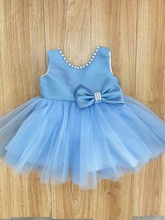 Celebrate the special occasions in your little one's life with our Soft Blue Pearl Baby Girl Tutu Dress. This enchanting ensemble adds a touch of elegance and glamour to any formal event with its soft blue color and delicate pearl accents. Made from the most comfortable, lightweight tulle, your little one will be able to move and play freely, while still looking party-ready. The satin waistband ensures a snug fit and adds charm with its beautiful bow detail. The dress's layered tutu skirt is ado Baby Blue Baby Dress, Pink Tutu Dress, Girls Tutu Dresses, Fancy Dress Up, Girl Tutu, Baby Pearls, Clothes Girl