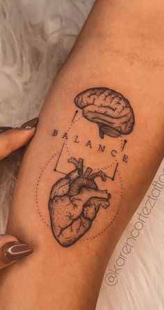 a woman's leg with a heart and brain tattoo on it