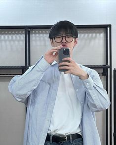 a man taking a selfie in front of a mirror with his cell phone up to his ear