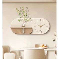 a clock mounted to the side of a wall next to a table with chairs and a potted plant