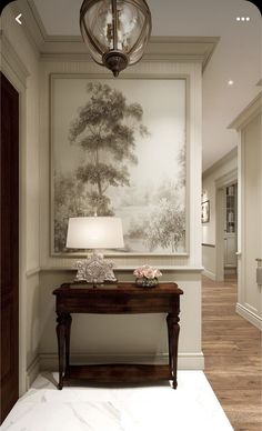 a room with a lamp, table and painting on the wall in it's corner