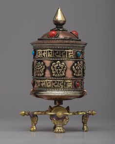 an ornately decorated metal box with red and blue stones on it's lid