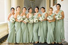 a group of women standing next to each other holding bouquets in their hands and smiling at the camera