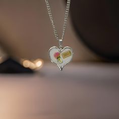 ✨ *Are you ready to explore the world, or perhaps, gift someone special the reminder to chase their dreams? This beautiful heart-shaped pendant necklace is a gentle nod to adventure, adorned with a delicate floral illustration and a whimsical 'Ticket to Anywhere' tag.* ✨ **Product Features - **Design A silver-tone heart pendant with a stunning floral decal, featuring a soft pink flower in a vase and a'Ticket to Anywhere' decal - **Material High-quality silver alloy, durable and lightweight, perf Meaningful Heart-shaped Keepsake Necklace, Valentine's Day Gift Charm Necklace With Lobster Clasp, Valentine's Day Gift Charm Necklace, Mother's Day Heart Pendant Necklace With Lobster Clasp, Heart Pendant Necklace With Charms For Mother's Day, Mother's Day Heart Pendant Necklace With Charms, Meaningful White Necklaces For Gifts, Meaningful White Necklace For Gift, Mother's Day Gift Heart Necklace With Charms