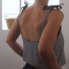 a woman with her back to the camera wearing a black and white checkered top