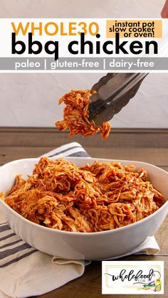 a white bowl filled with shredded chicken on top of a wooden table