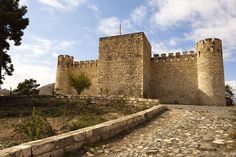 an old stone castle sitting on top of a hill