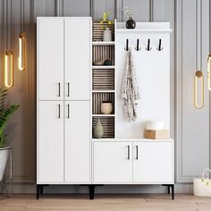 a white and brown cabinet with hooks on the wall next to a potted plant