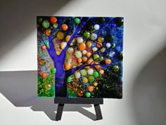 a painting on a easel with an orange tree and blue sky in the background