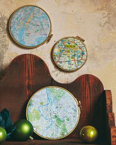 three cross stitch maps are hanging on the wall next to christmas ornaments and other decorations