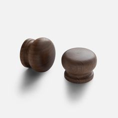 two wooden knobs are shown against a white background, one is turned to the side