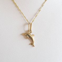 Dolphin charm.  Dolphin gold charm. 9 carat yellow gold charm.  It can be worn on a chain or a bracelet. The charm measures 1.4x1.3cms The charm is ready to ship in 1-2 working days.   All my pieces come in a velvet ring box.  I am highly conscious of environmental damage that extra packaging can create so my pieces come in appropriate jewellery box only with ho extra packaging. This item qualifies for free shipping. Yellow Gold Charm Bracelet With Dangle Shape, Yellow Gold Dangle Charms For Gifts, Yellow Gold Dangle Charm Bracelet Gift, Gold Round Pendant Charm With Lobster Clasp, Gold Pendant Charms With Dainty Style, Gold Dainty Pendant Charms, Dainty Gold Pendant Charms, Dainty Yellow Gold Dangle Charms, Classic 14k Gold Charms Necklace