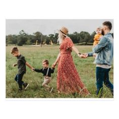 a family holding hands and walking through a field