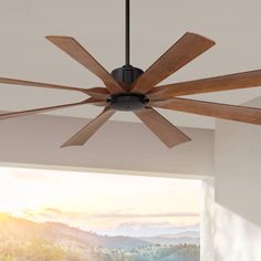 a ceiling fan with wooden blades in a room