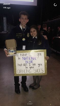 a man and woman standing next to each other holding a sign that says i love you in national deb