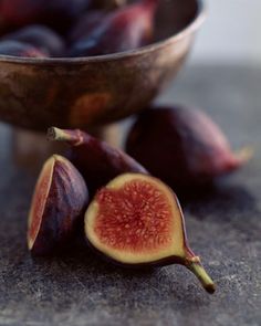 some figs that are on the ground next to a bowl