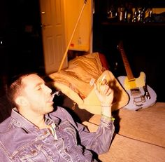 a man sitting on a couch holding a wine glass in his right hand and looking up at the sky