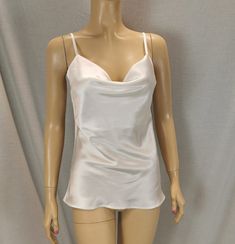 A satin top with a waterfall neckline will provide the basis for a sensual look. The model is made of lightly elastic shiny satin fabric. The fit can be easily adjusted using sliders on narrow straps. The top easily expands towards the bottom. The flowing, smooth fabric glides pleasantly over the body. Excellent workmanship: neat flat seams, metal regulators with a durable gold-colored coating. We offer tops in different colors: -ecri -white - red - blue - black Dimensions: S. chest width 92 cm M. width at chest line 96 cm L. chest width 100 cm Xl. width along the chest line. 104 cm Top length 45-50 cm depending on size. If your size differs from those offered, please contact the seller. We will try to fulfill your order. Satin Tank Top With Built-in Bra, White Tops With Adjustable Straps For Party, White Party Tops With Adjustable Straps, Elegant White Tank Top With Adjustable Straps, White Tank Top With Adjustable Straps For Night Out, Solid Satin Tank Top For Party, Satin Camisole Tank Top For Party, Elegant White Top With Tank Straps, Elegant White Tank Top With Straps