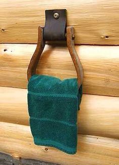 a green towel hanging from a hook on a log wall