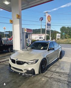 a white car parked in front of a gas station