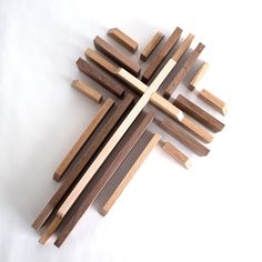 a cross made out of wooden sticks on a white surface