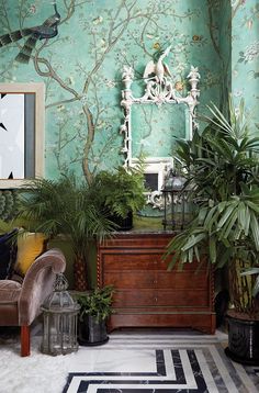 a living room filled with furniture and lots of green plants in front of a mirror