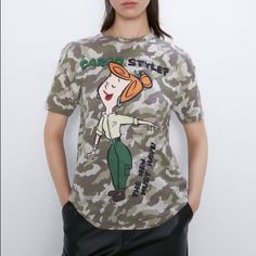 How Chic Is Wilma!? Love Camouflage Background.. Fun Addition For Graphic T-Shirt Collections Relaxed Fit Camouflage T-shirt With Graphic Print, Trendy Khaki Crew Neck T-shirt, Camouflage Graphic Print Relaxed Fit Tops, Camouflage Graphic Tee With Print, Camouflage Crew Neck Graphic Tee, Fall Camouflage T-shirt With Crew Neck, Camouflage Graphic Print Relaxed Fit T-shirt, Khaki Graphic Print Short Sleeve Tops, Trendy Khaki Short Sleeve T-shirt